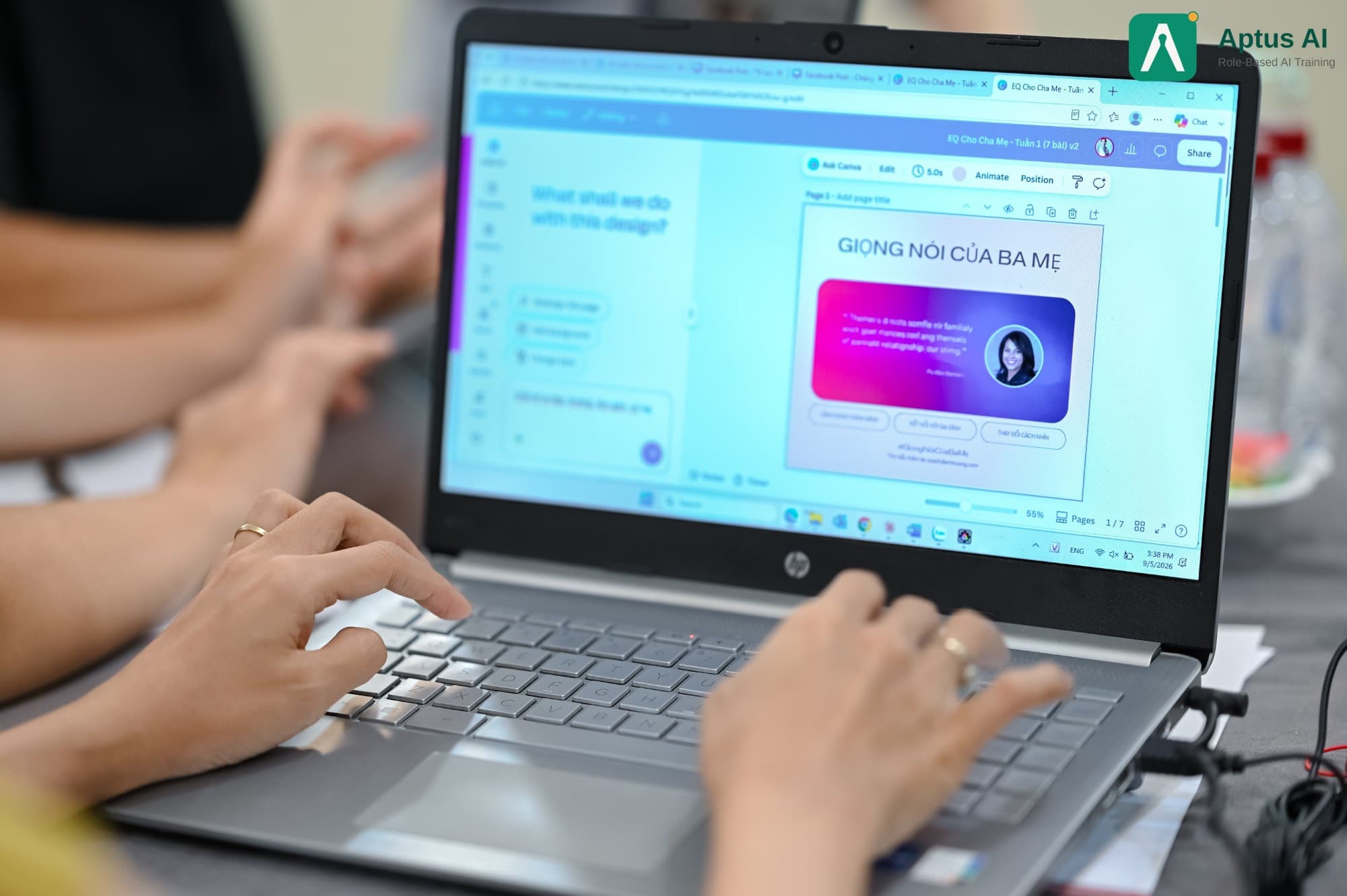 Hai bàn tay gõ phím laptop HP, màn hình mở một slide Canva do học viên đang chỉnh trong lớp